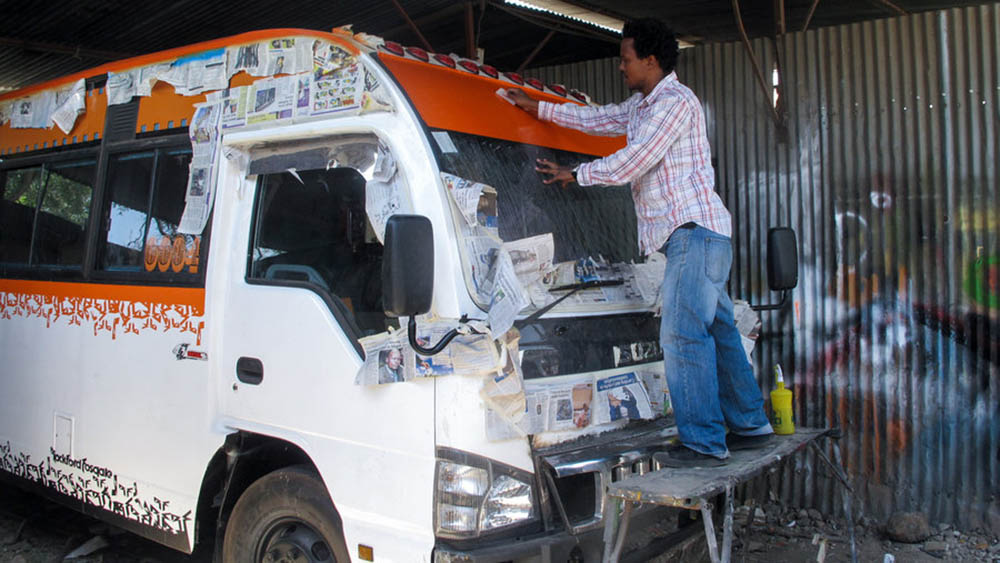 Matatus_grafitti artist painting a matatu